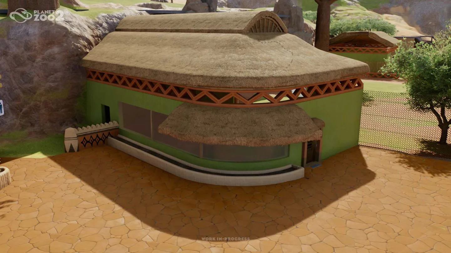 A rounded zoo building with a glazed front and thatched roof